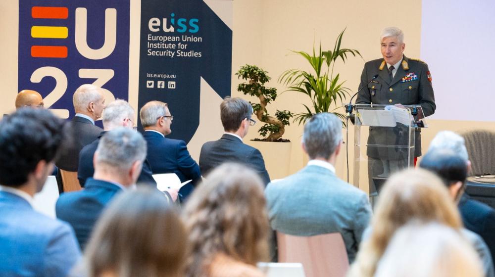 Image of a person at a lectern delivering remarks © BR&U