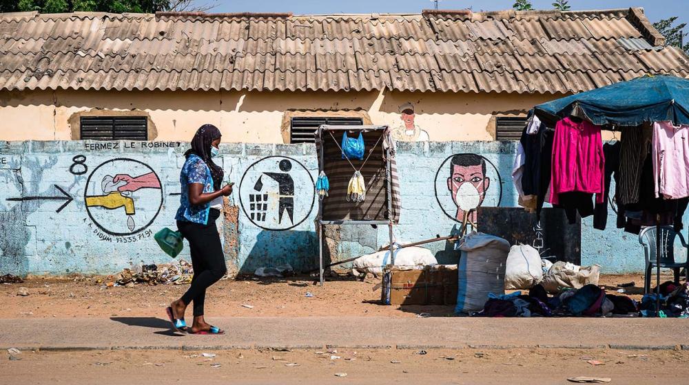 Image of a woman walking wearing a health mask © Unsplash